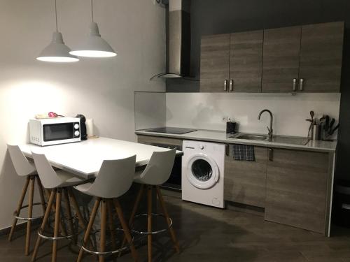 卡斯特拉讷Studio Centre ville Castellane的厨房配有带微波炉的桌子和洗衣机。