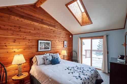 SchroederHeart of Superior Lake Cabin 15 Mi to Lutsen Mtn!的一间卧室设有木墙、一张床和一个窗户