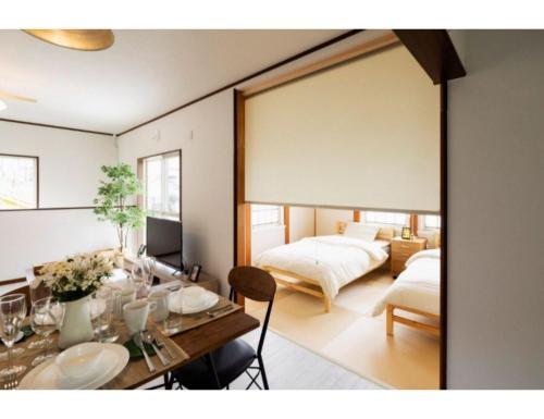 明石市Anjin Stay Awaji - Self Check-In Only的客厅配有桌子和两张床