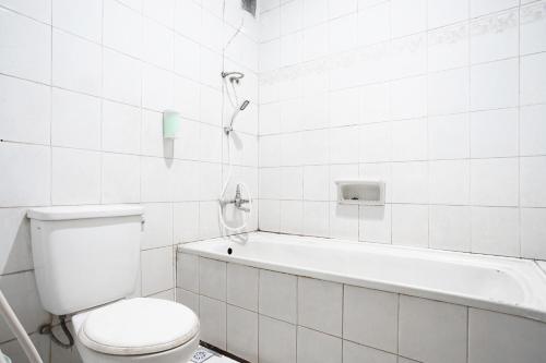 万隆Hotel Bandung Permai的白色的浴室设有卫生间和浴缸。