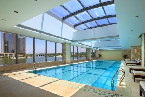 绍兴绍兴世茂皇冠假日酒店的一座带玻璃天花板的建筑中的游泳池