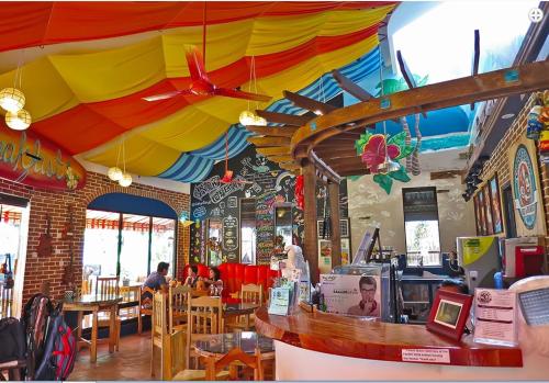 杜马格特Gabby's Bed & Breakfast的柜台上方有彩雨伞的餐厅