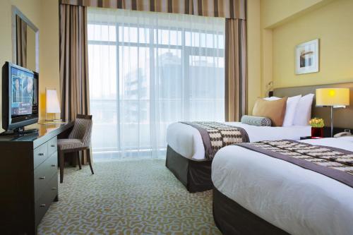 迪拜TIME橡木酒店及套房的酒店客房设有两张床和电视。