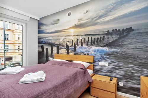 斯维诺乌伊希切Premium Apartments Lissa by Renters的一间卧室,配有一幅大幅海洋画