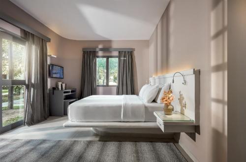 杰里科科拉吾之蓝酒店的卧室设有一张白色大床和一扇窗户。