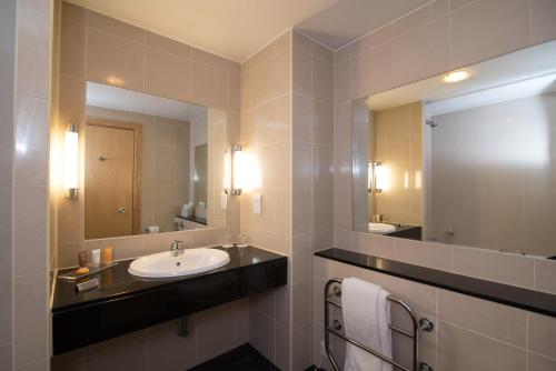 纽伯里Regency Park Hotel, Health Club & Spa的一间带水槽和大镜子的浴室