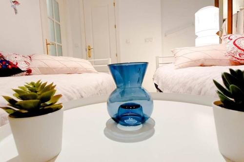 塞维利亚Apartamento Suite Next to Catedral的坐在桌子上的蓝色花瓶