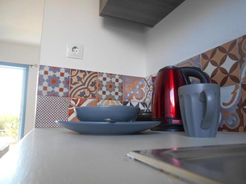 阿里克斯海景观公寓酒店的厨房柜台上备有盘子和咖啡杯
