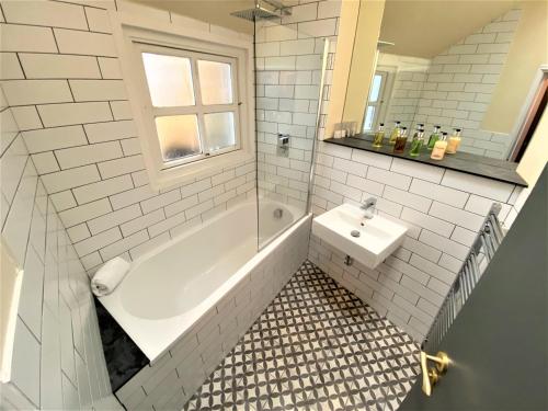 利兹利明克莱蒙特公寓的白色的浴室设有浴缸和水槽。
