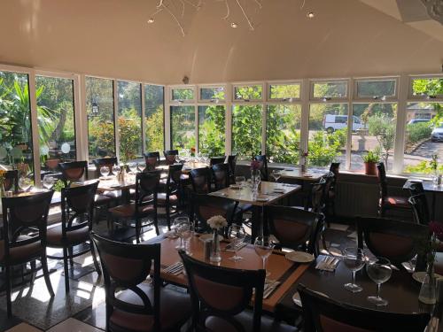 盖茨黑德Michelangelos - Rooms, Restaurant & Bar的用餐室设有桌椅和窗户。
