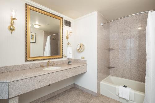 里士满伯克利酒店的一间带水槽、浴缸和镜子的浴室