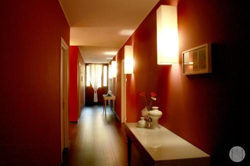 阿尔库阿佩特拉尔卡罗坎达威利达利姆宾馆的走廊上设有红色的墙壁和白色的桌子