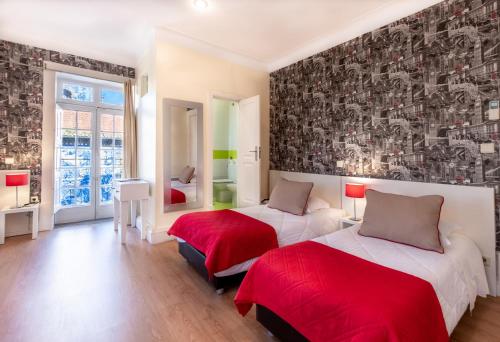 波尔图北方酒店的一间卧室配有两张红色床单