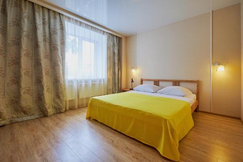 托木斯克ОК! Советская, 69 №7的一间卧室设有黄色的床和窗户。