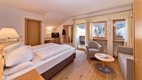 瓦尔道拉Hotel Post - OlangCard included的酒店客房带一张床、椅子和窗户