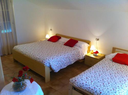 多马索杰拉尼欧住宅酒店的一间卧室配有两张带红色枕头的床。
