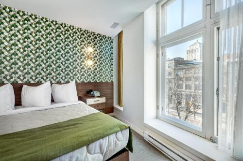 蒙特利尔Hôtel Uville Montréal的一间卧室设有一张床和一个窗口