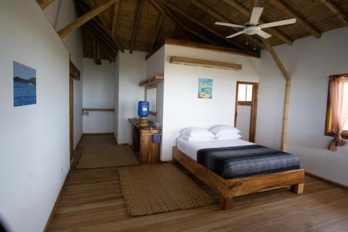 卡诺阿Canoa Suites的一间卧室配有一张床和吊扇
