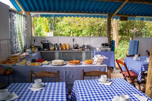 蒂拉登特斯João e Maria Restaurante e Chalés的一间设有两张桌子的餐厅和一个柜台,上面有食物