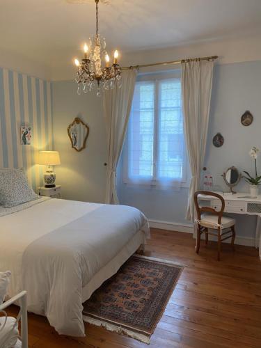 达克斯La Croix Blanche的卧室配有白色的床和吊灯。