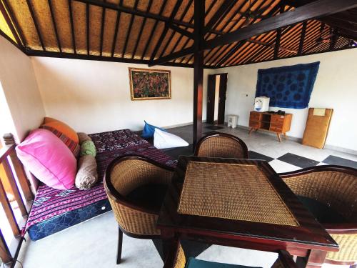 金巴兰Capung Guesthouse的配有一张床和一张桌子及椅子的房间