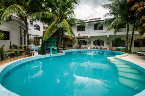 宿务Cebu Hilltop Hotel的棕榈树酒店前的游泳池