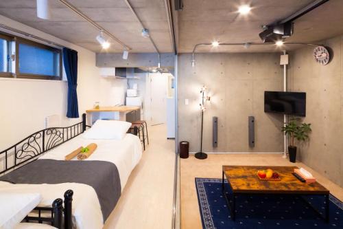 东京Laffitte Hirai Condominium Hotel的客房设有两张床、一张桌子和一台电视机。