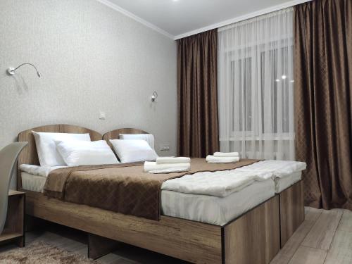 卡拉科尔Lux Apartment Karakol Center的卧室配有带白色枕头的大床