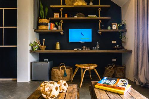 爱妮岛El Nido Boutique Vacation Villas的客厅配有桌子,墙上配有电视
