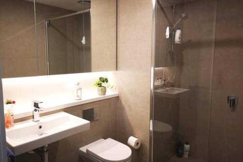 悉尼Modern apartment+office w Parking @ Olympic Park的浴室配有卫生间、盥洗盆和淋浴。