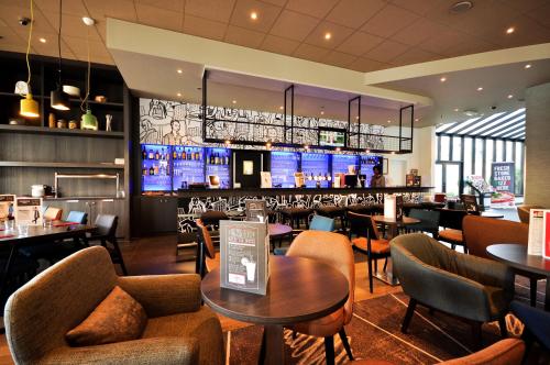 布鲁塞尔布鲁塞尔市中心南站宜必思酒店的一间带桌椅的餐厅和一间酒吧