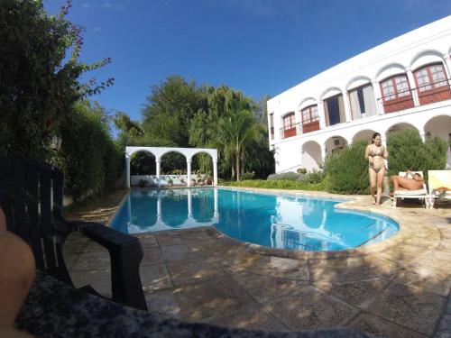 卡法亚特Hotel Portal del Santo的站在带游泳池的房子前面的女人