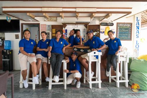 San JoseLanas Beach Resort的一群穿着蓝色衬衫的人,为一张照片做假装