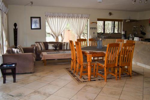 比勒陀利亚Baobab - NUDE - SunEden Family Naturist Resort的厨房以及带桌椅的起居室。