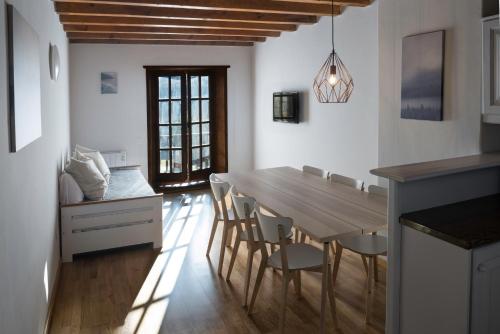 普拉德埃米塔SNÖ Vall de Boí的厨房以及带木桌和椅子的用餐室。