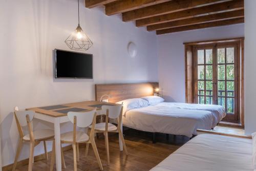 普拉德埃米塔SNÖ Vall de Boí的一间卧室配有两张床和一张桌子及椅子