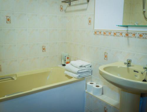 黑尔斯沃思Blyth Lodge B&B的带浴缸、水槽和毛巾的浴室