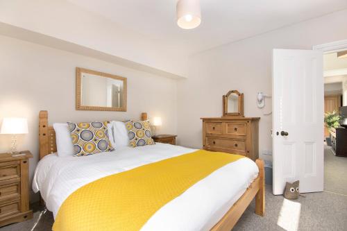 索尔兹伯里Salt Lane Apartments的一间卧室配有一张带黄色毯子的大床