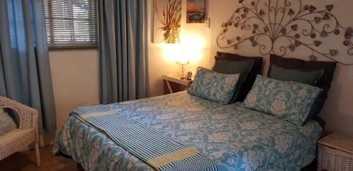 雾观A Farm Stay - Casablanca's Private Cottage,no loadshedding!的一间卧室配有一张带蓝色棉被的床