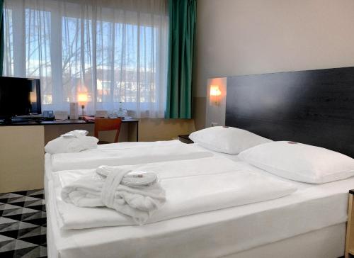 柏林acom Hotel Berlin City Sued的酒店客房,配有两张带毛巾的床