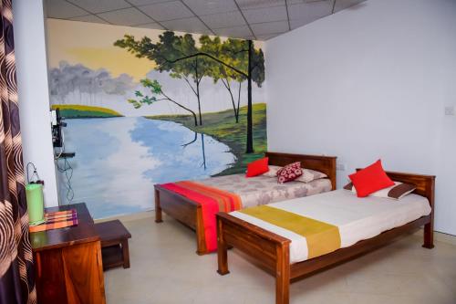 蒂瑟默哈拉默Hotel Mount Valley & Yala Safari的一间设有两张床的客房,墙上挂着一幅画