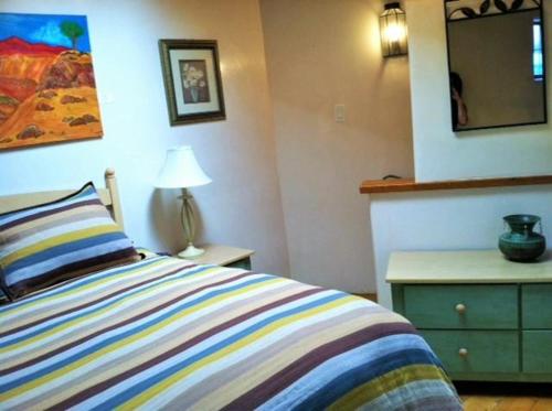 圣达菲Casas de Guadalupe - Sante Fe Vacation Rentals的一间卧室配有一张床、梳妆台和镜子