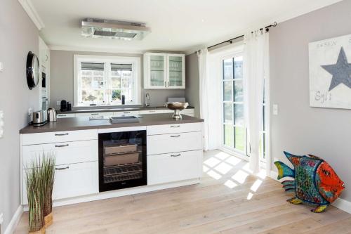 里斯特Beachalm的厨房配有白色橱柜和炉灶。