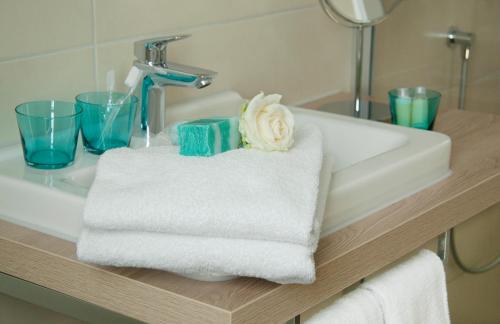 艾汀克拉罗格尼住宿加早餐旅馆的浴室水槽配有毛巾和花卉