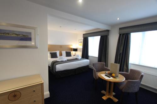 托基Belgrave Sands Hotel & Spa的酒店客房配有一张床、一张书桌和一台笔记本电脑