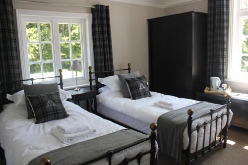 东考斯威尔斯王子酒店的一间卧室设有两张床和两个窗户。