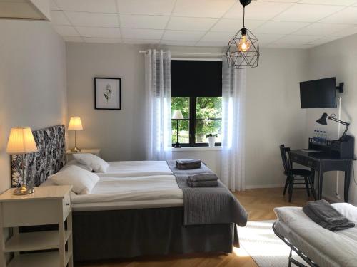 DegerforsDegerfors Bed & Breakfast的一间卧室配有一张床、一张书桌和一个窗户。