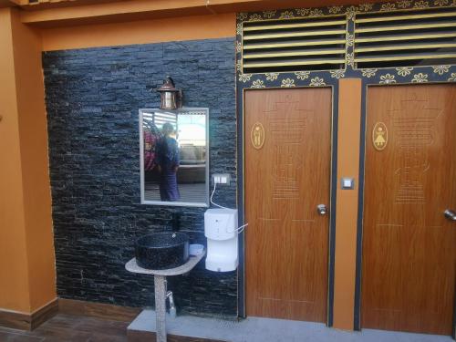 廷布Ludrong Hotel的浴室设有卫生间,墙上设有镜子