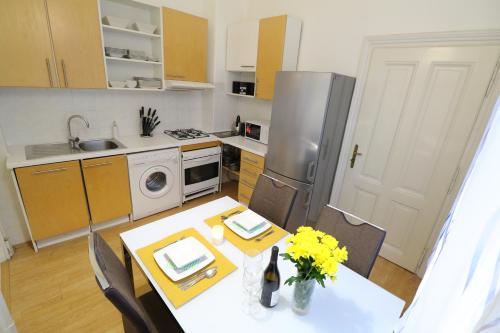 布拉迪斯拉发Apartment HVIEZDKO的一间带桌子的厨房和一间带冰箱的厨房
