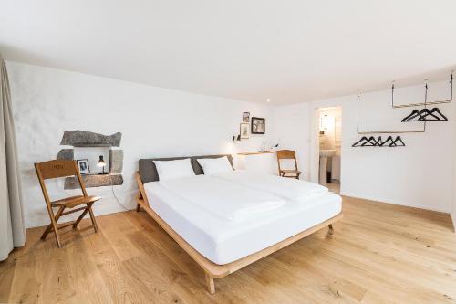 苏黎世Montmartre的卧室配有一张白色大床和一把椅子